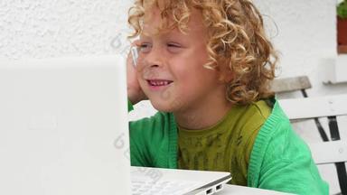金发碧眼的男孩玩智能手机移动PC